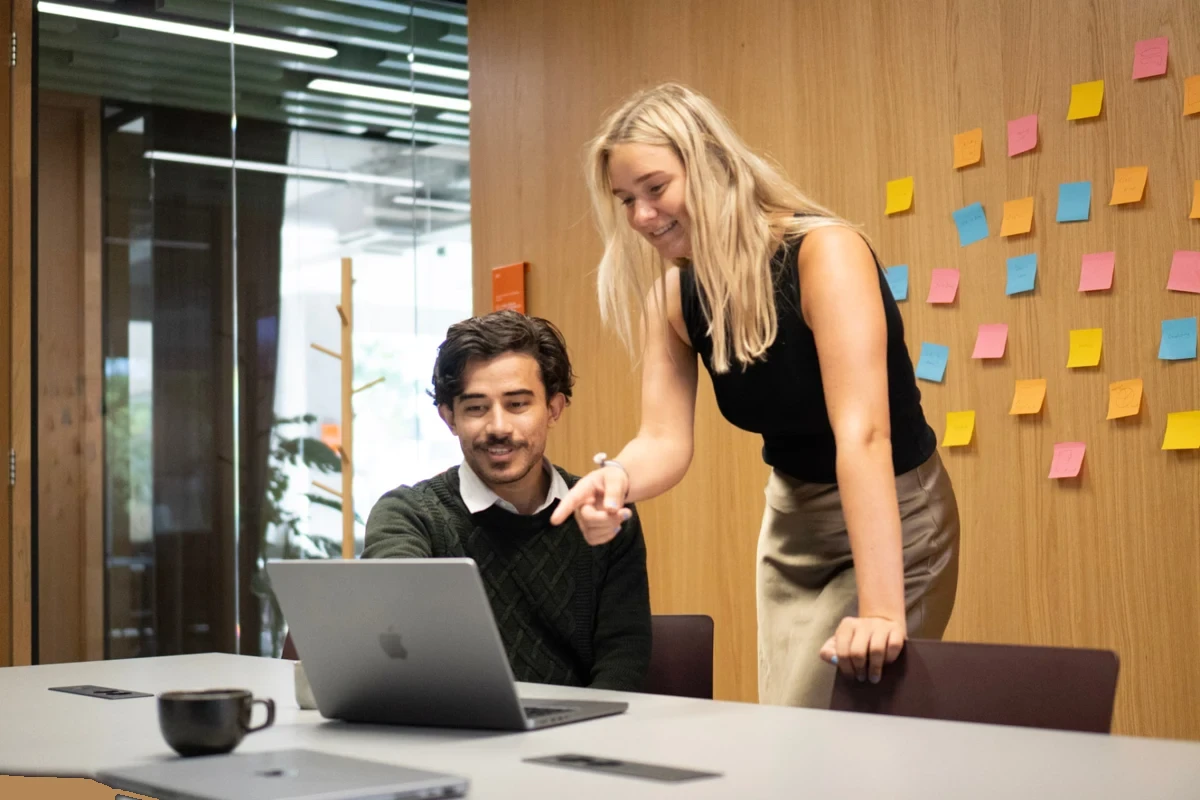 Twee collega's bespreken samen het carrièrepad achter een laptop