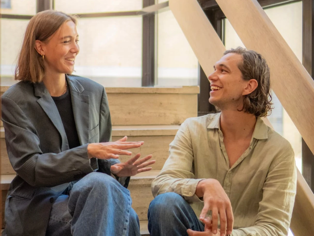 Leidinggevende en medewerker in gesprek op de trap