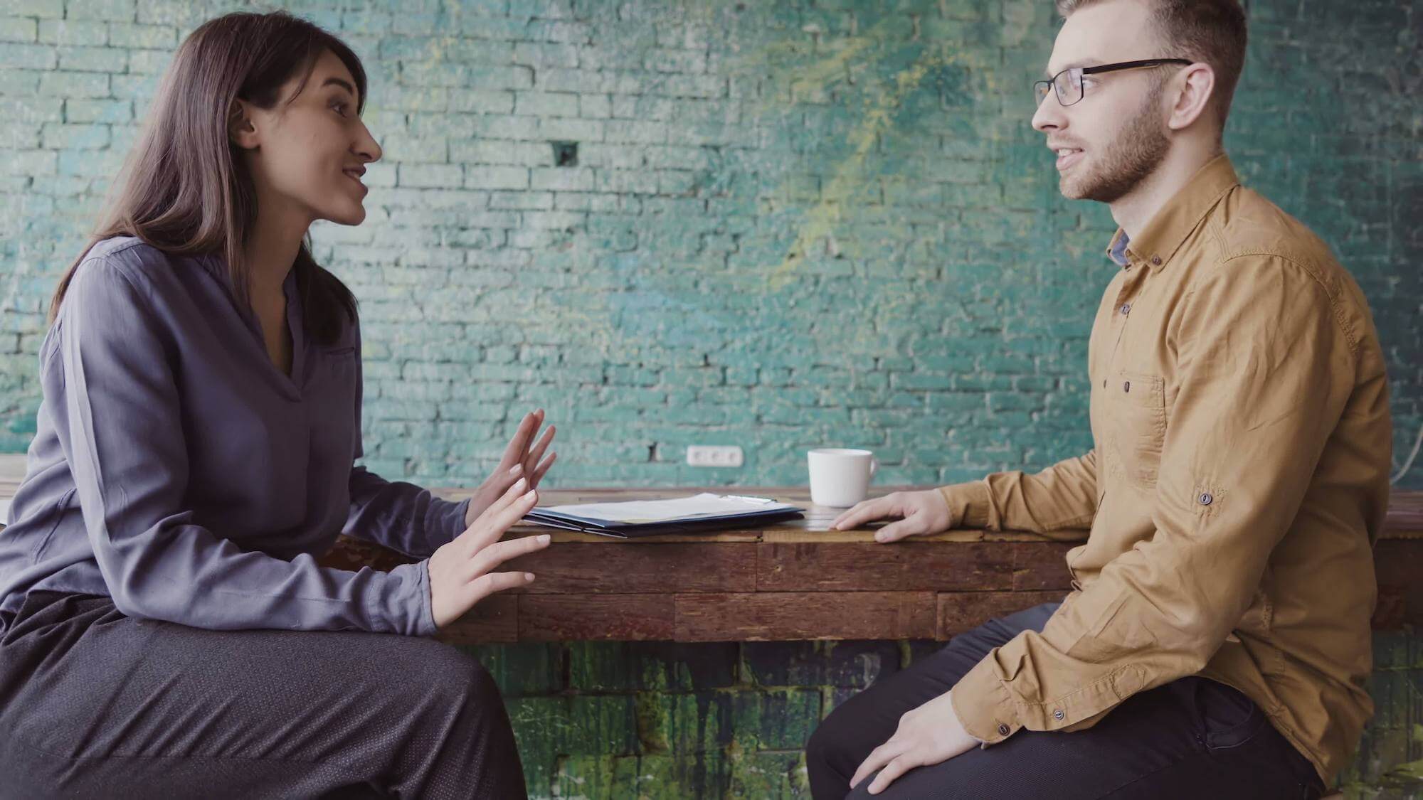 HR Manager en medewerker voeren Het goede gesprek aan tafel met koffie