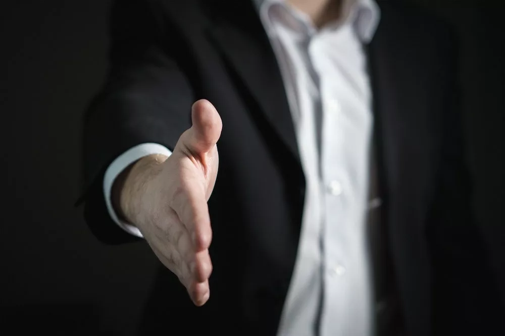 Man steekt hand uit om hand te schudden