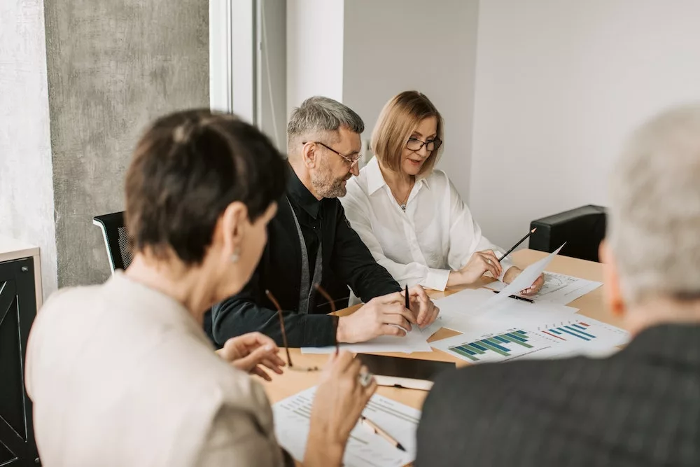 medewerkers kijken naar documenten en zijn aan het overleggen