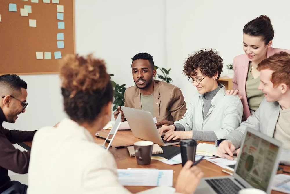 Medewerkers brainstormen terwijl ze achter hun laptop zitten