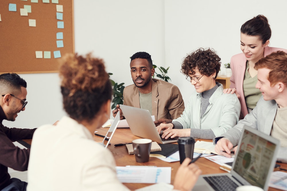 Medewerkers brainstormen terwijl ze achter hun laptop zitten